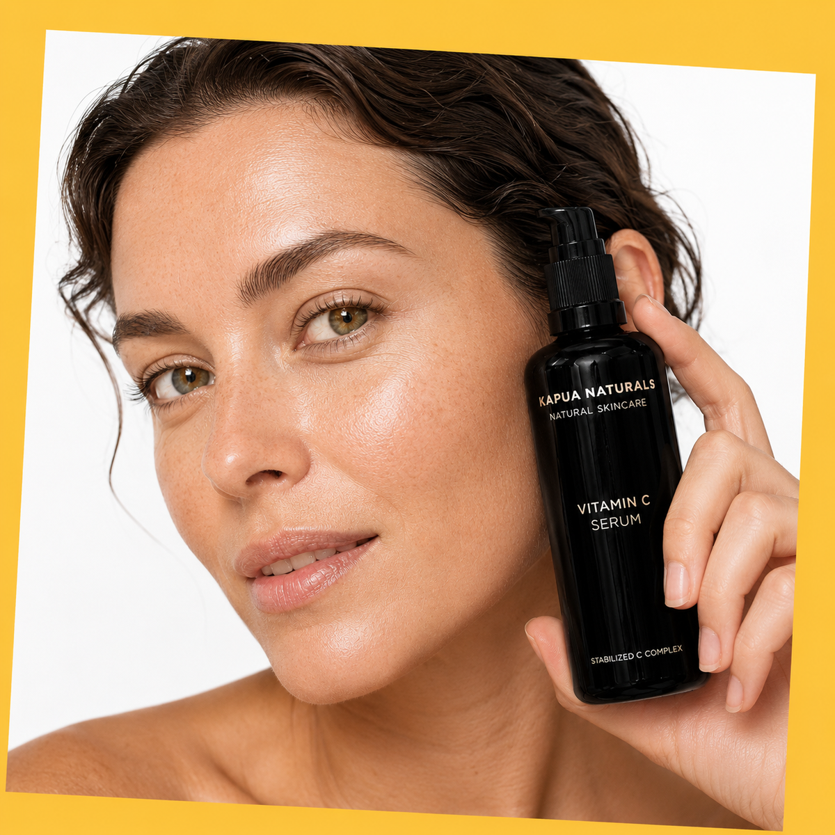 Bio Vitamin C Serum – Model hält Serum vor warmgelbem Hintergrund