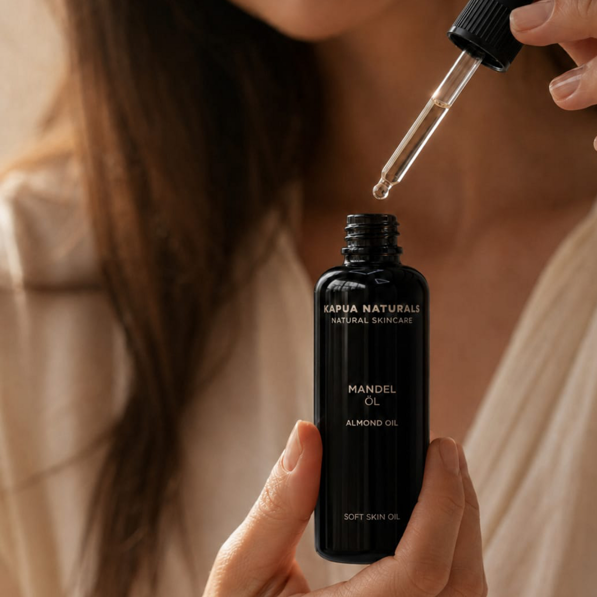 Pipette mit Mandelöl über der geöffneten Kapua-Naturals-Flasche