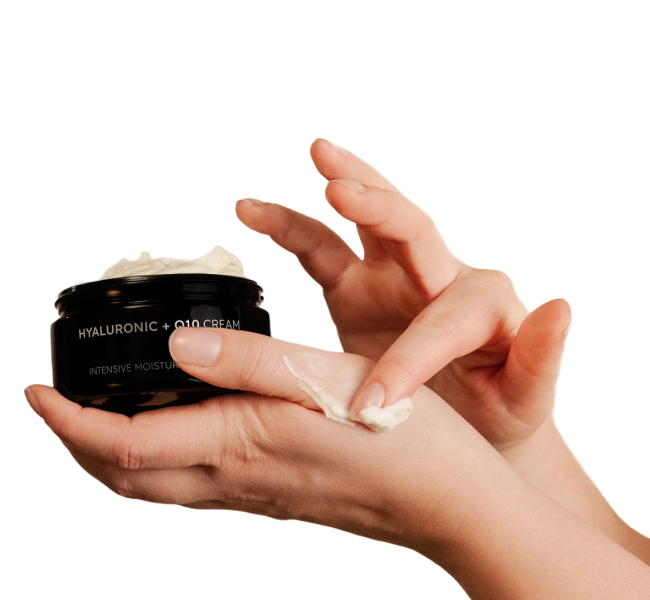 Q10 Creme wird mit der Fingerspitze aus dem Violettglastiegel entnommen