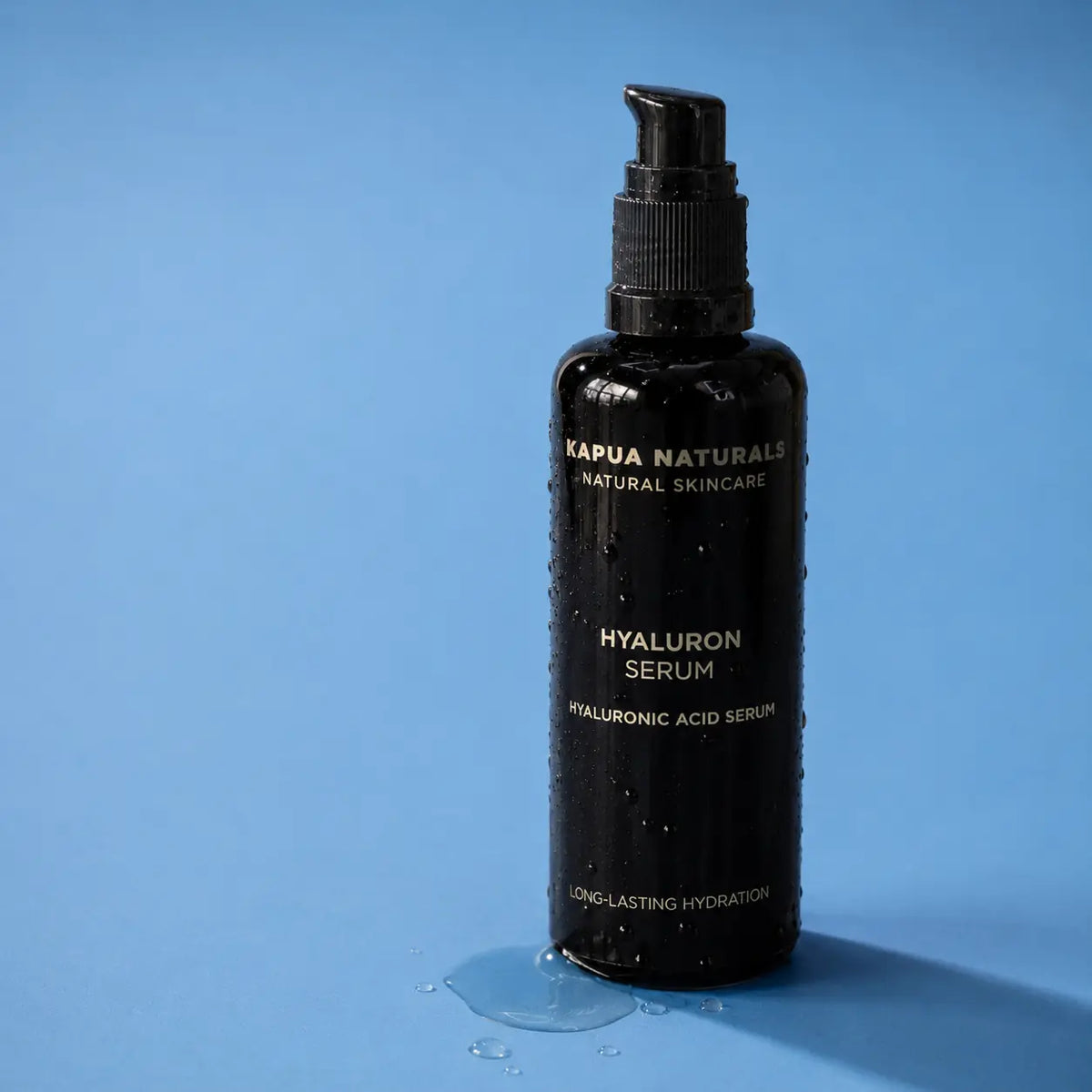 Kapua Hyaluron Serum mit Wassertropfen auf hellblauer Fläche